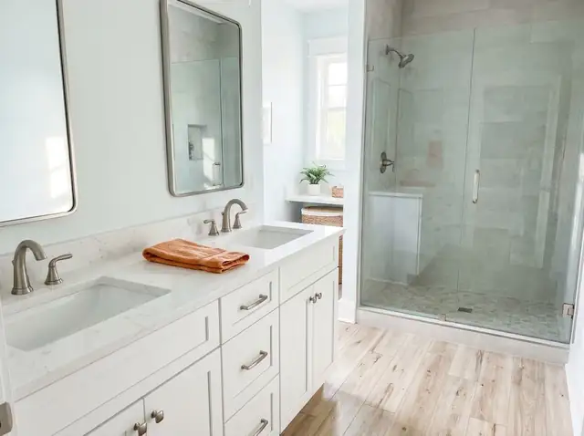 Bright coastal-style bathroom with a white vanity and a glass walk-in shower (illustration)